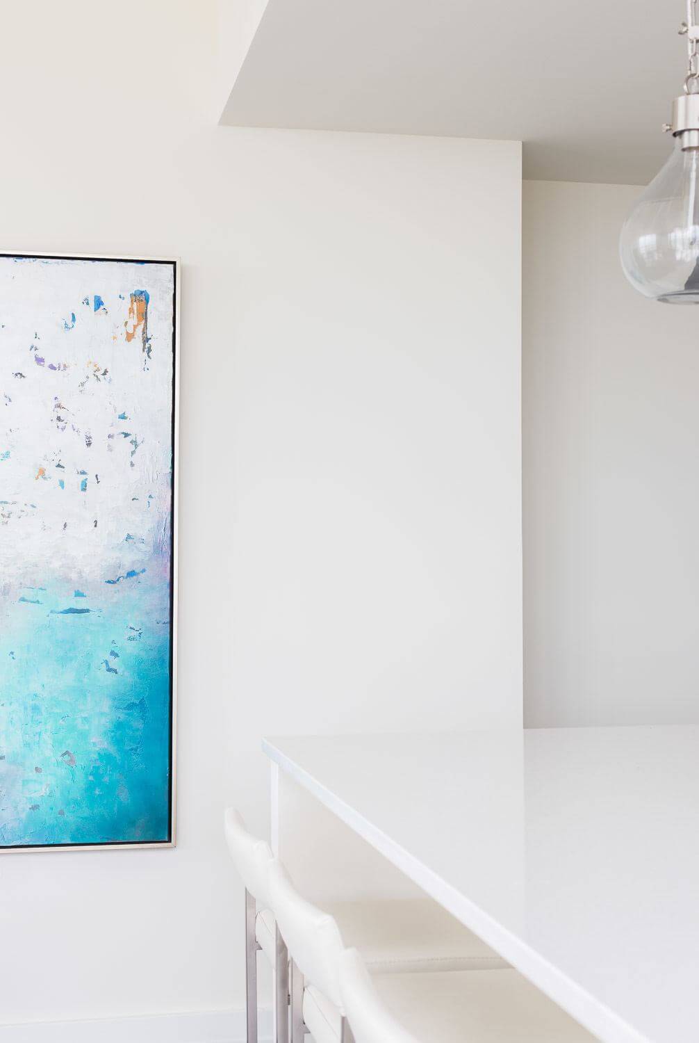The neutral kitchen is enlivened by a colorful piece of art. The neutral kitchen is enlivened by a colorful piece of art in this twelve twelve Nashville home. ©Alyssa Rosenheck Photography