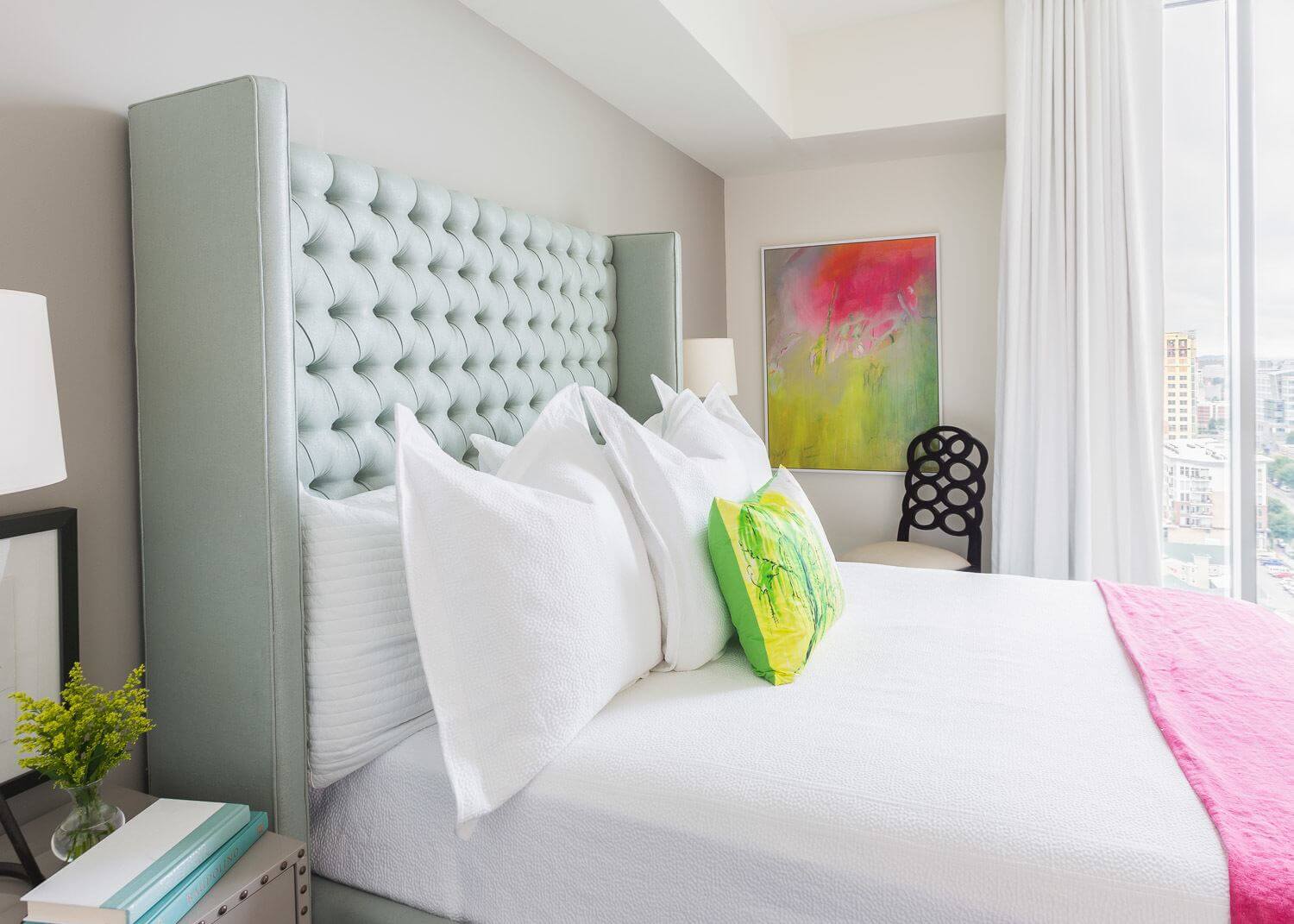 The artwork on the bedroom's wall ties in the colors of the headboard, pillow and throw. The artwork on the bedroom's wall ties in the colors of the headboard, pillow and throw. ©Alyssa Rosenheck Photography