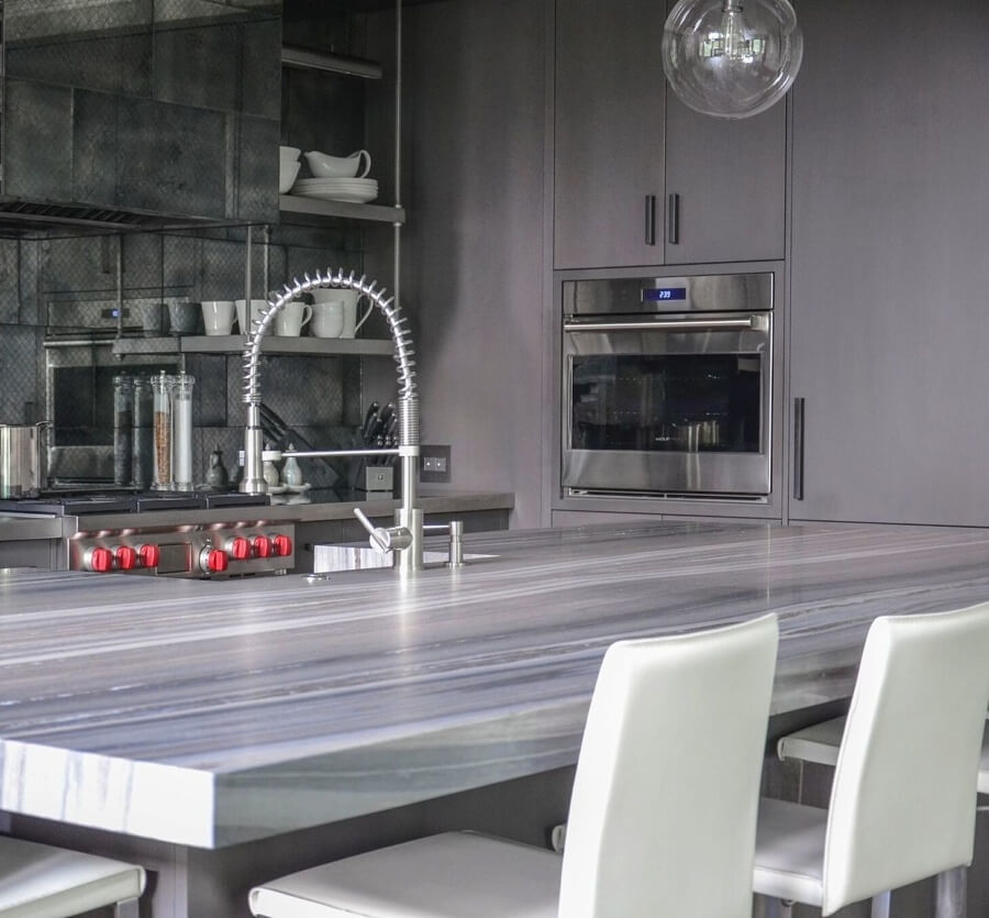 The Parma faucet by Danze (danze.com) joins a stainless-steel farmhouse sink, yet another example of how the design team took a traditional concept (farmhouse sink) and gave it a modern twist. Staggered globe light fixtures are from Marty Mason Home (mmcollectedhome.com).