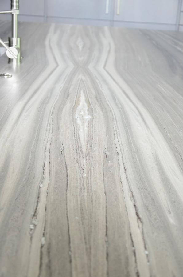 A heavily veined marble countertop becomes a work of art in the kitchen. "To cover the 138" x 66" island we used four slabs of material and butterflied them, which created a four-way mirror image," explains Kelly. "The countertop has 32 seams in it, which are almost invisible to the naked eye."