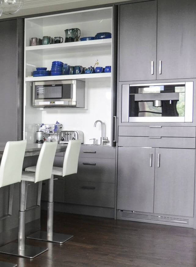 Cabinet doors open to a swanky appliance garage, complete with prep sink.