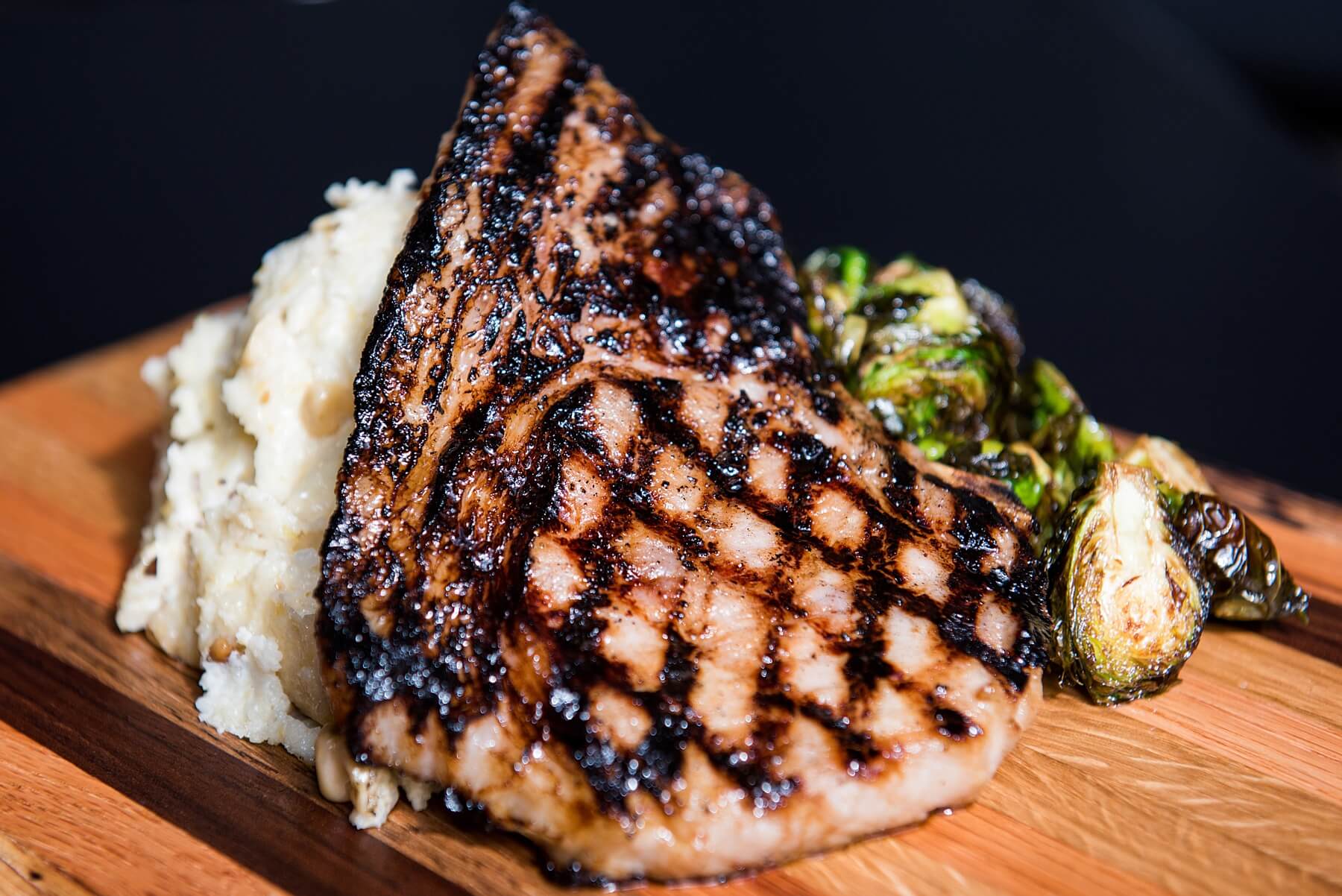 U.S.-born-and-raised, certified black angus Creekstone Farms flat-iron steak, grilled to order with herb butter, served with smashed potatoes and charred Brussels sprouts. U.S.-born-and-raised, certified black angus Creekstone Farms flat-iron steak, grilled to order with herb butter, served with smashed potatoes and charred Brussels sprouts.