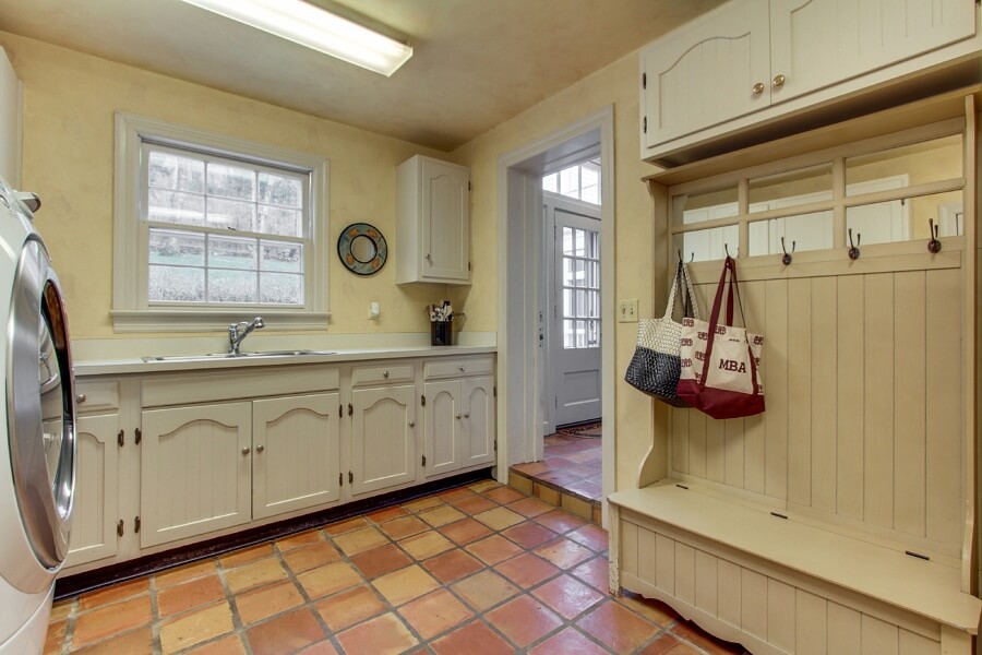 The laundry room features plenty of counter space, a sink, storage and hooks that act as a home for backpacks and coats. The laundry room features plenty of counter space, a sink, storage and hooks that act as a home for backpacks and coats.