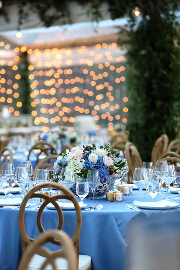 The blue adds a lovely contrast to the flowers, greenery and twinkling lights.