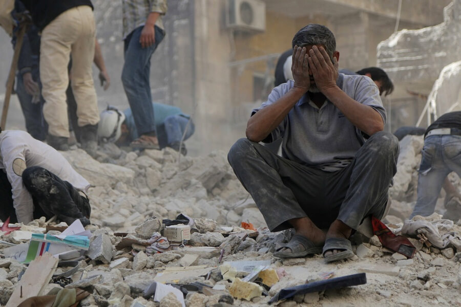 A man reacts amid debris after what activists said were explosive barrels thrown by forces loyal to Syria's President Bashar al-Assad in Al-Shaar neighbourhood of Aleppo April 27, 2014. REUTERS/Hosam Katan (SYRIA - Tags: POLITICS CONFLICT TPX IMAGES OF THE DAY) - RTR3MTUG