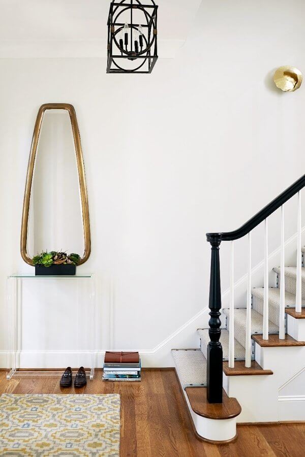 “The foyer area is small but we wanted to have a drop spot for guests and welcoming entry,” says interior designer Kara Cox. “The Lucite console and large mirror add a lightness and whimsy while the geometric Tibetan rug from Moattar (moattar.com) grounds the small space with a modern touch.”
