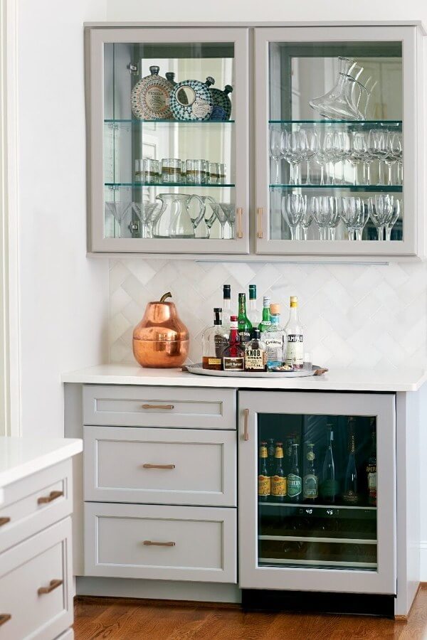 “We added upper cabinets in the bar area to add function with extra storage,” says Kara. “By backing the upper cabinets in mirrors, we reflected light to an interior wall that did not have windows.”