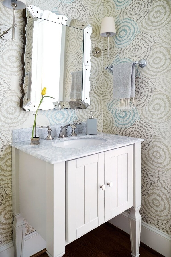 The powder room had an existing vanity in a darker gray that Kara repainted in a lighter finish. “We then added the Zoffany (zoffany.com) wallpaper, Bungalow 5 (bungalow5.com) mirror and small watercolor piece by Atlanta artist Erin McIntosh (erinmcintosh.com),” says the designer.” I love to layer pattern with art, so powder rooms are a great place to do this. You can add a pattern that’s harder to pull off in a large space but is a perfect punch in a smaller room.”