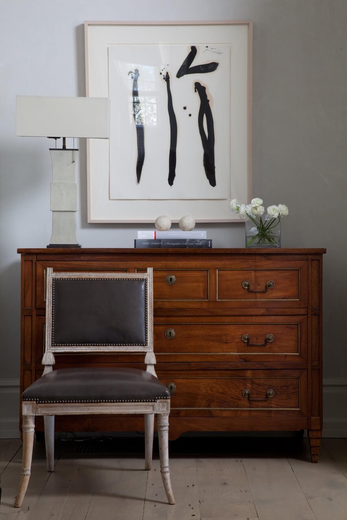 An antique Italian chest with Ziggurat legs is flanked by a 19th Century English regency chair in the entry of the home. Image: Miller Mobley