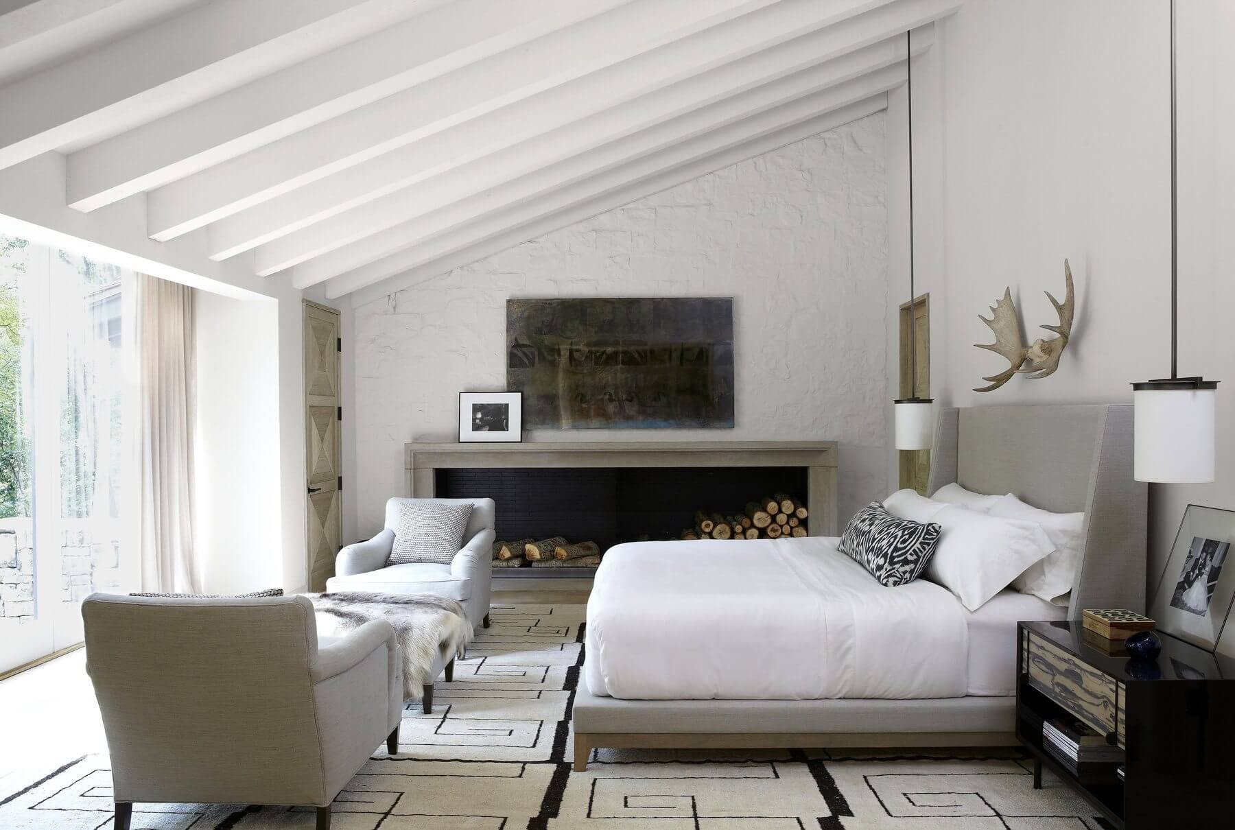 Betsy worked with Paul Bates Architects on the renovation of this mid-century modern house for two empty-nesters. Their master bedroom features a custom upholstered platform bed, a modern kelim rug from Paige Albright Orientals and art by Clayton Colvin above the modern fireplace. Image: Jean Allsopp 
