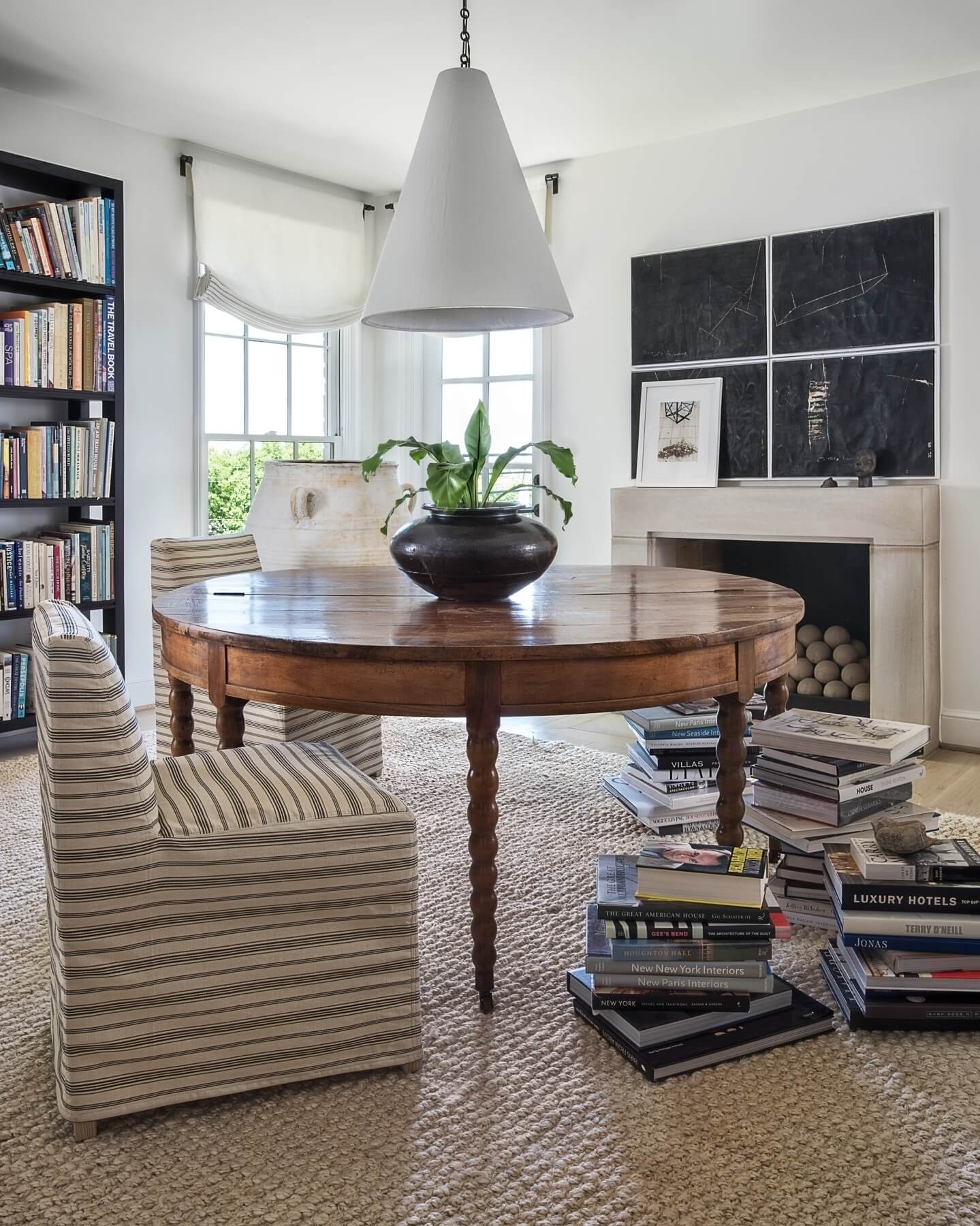 The library's 19th Century French drop-leaf table is topped with a plaster cone hanging light by Rose Uniacke. Image: Peter Vitale 