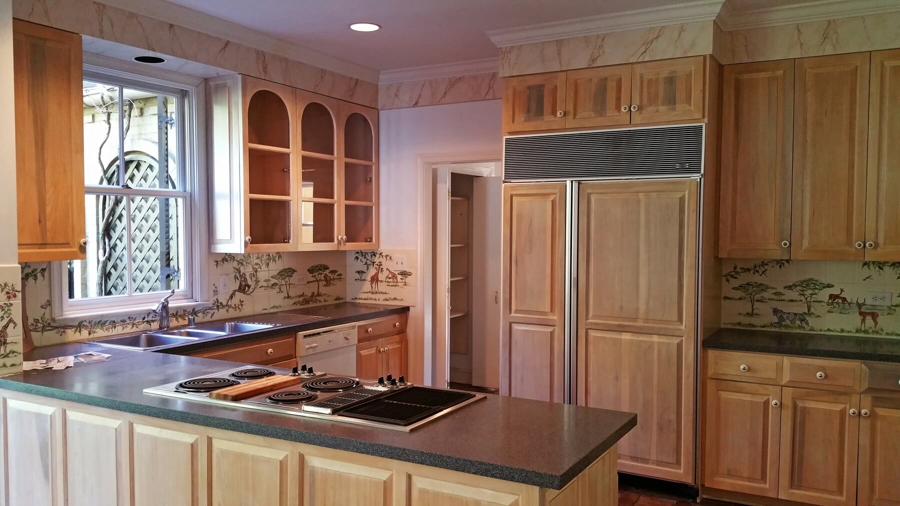Before: The kitchen had a more traditional look featuring tiles of African safari scenes. Before: The kitchen had a more traditional look featuring tiles of African safari scenes.