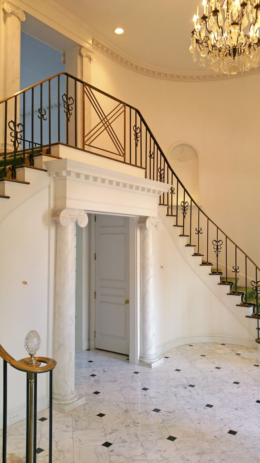 Before: The original foyer was all-white with a traditional chandelier and more iron flourishes on the staircase's handrail. Before: The original foyer was all-white with a traditional chandelier and more iron flourishes on the staircase's handrail.