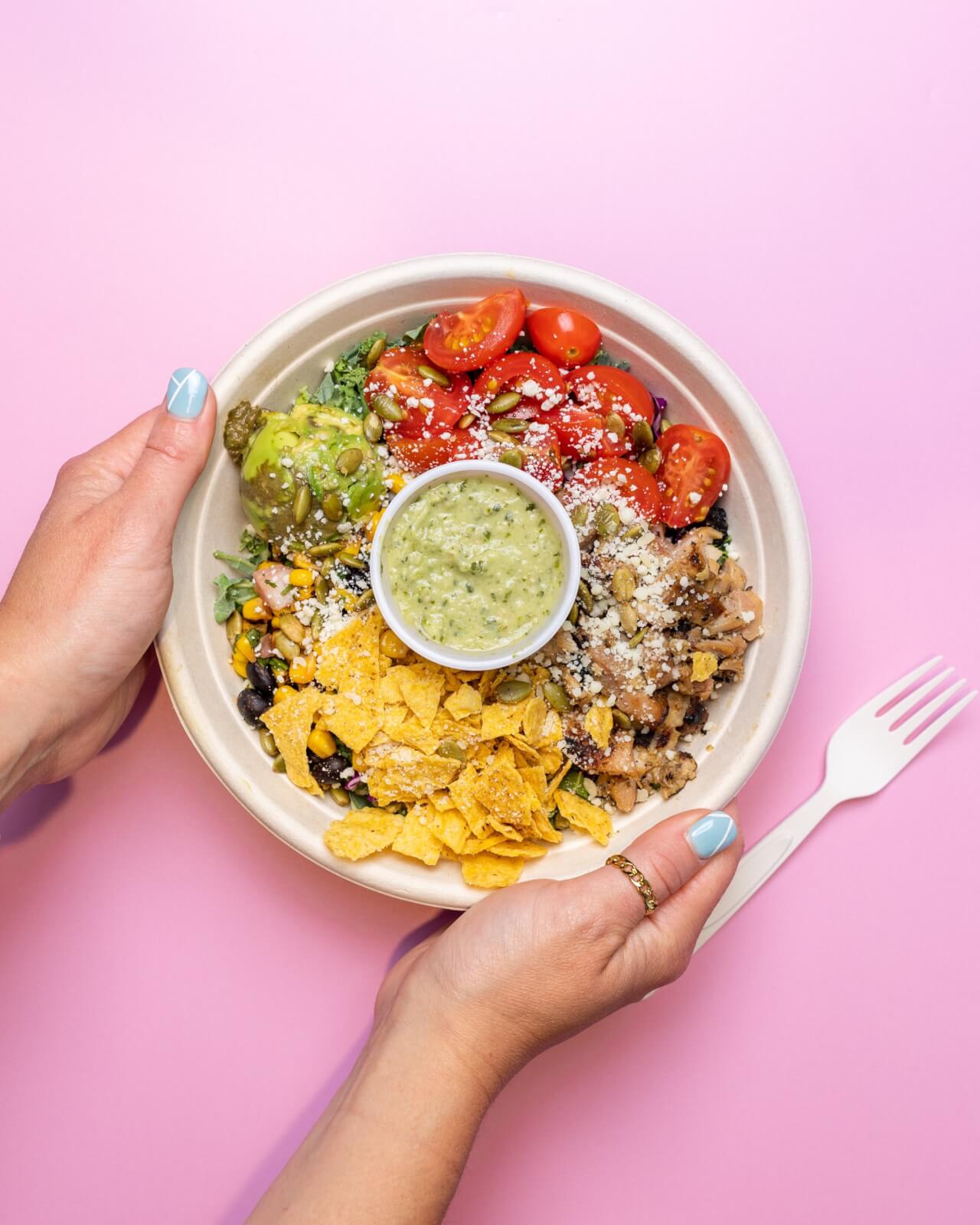 An Updated Guide to Sylvan Park: Where Friendly Faces & Dining Destinations Await - 11 Bowl from Radish Kitchen against a pink background.