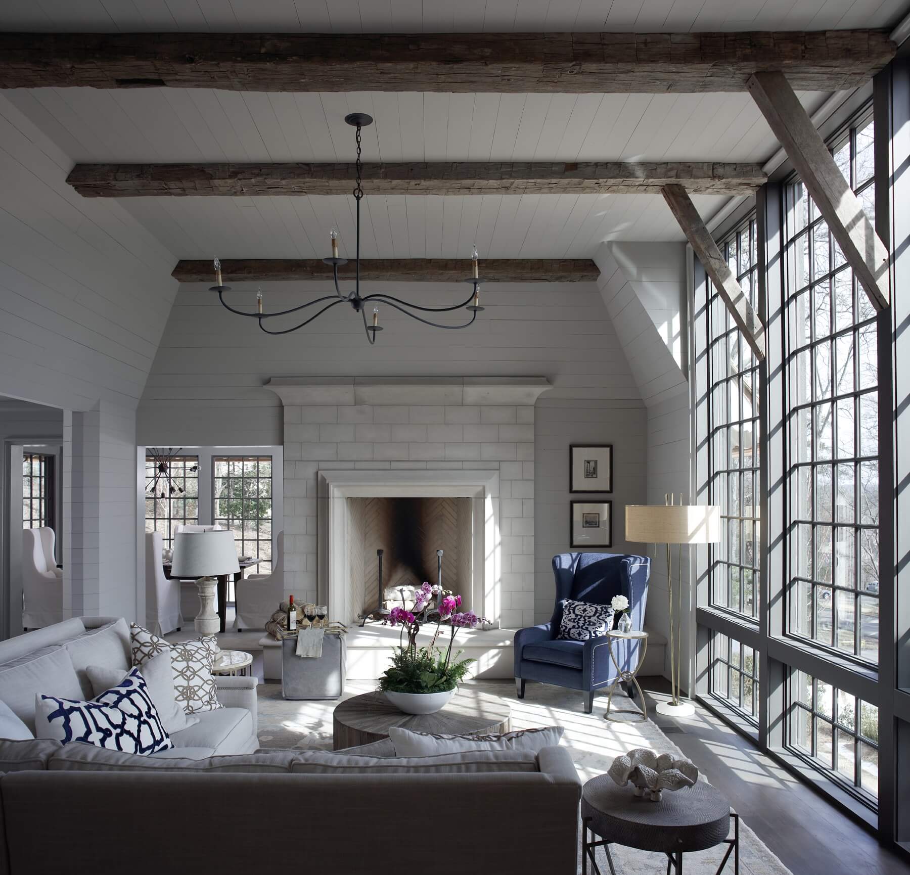 In this gracious keeping room, a wall of windows provides a seamless and calming union with nature. In this gracious keeping room, a wall of windows provides a seamless and calming union with nature.