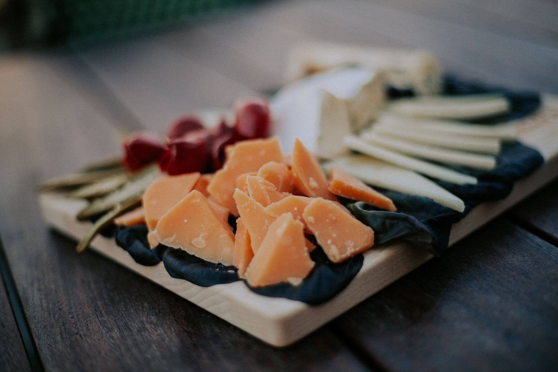 Different cheeses on a wooden board.