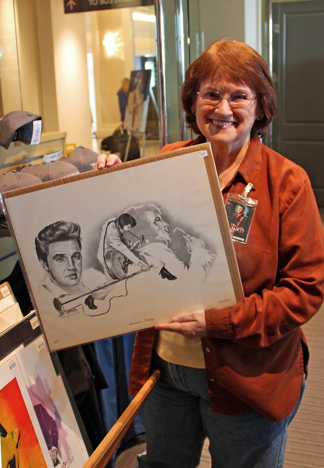 Nashville-based Betty Harper, the official artist for Elvis Presley Enterprises, has created more than 200,000 drawings of Elvis. She sold some of her prints in the Guest House gift shop on March 4, 2017, during the opening weekend of Elvis Presley’s Memphis. Here, she holds a print of the artwork the City of Memphis used on a 1978 billboard on Elvis Presley Boulevard on the first anniversary of his death.