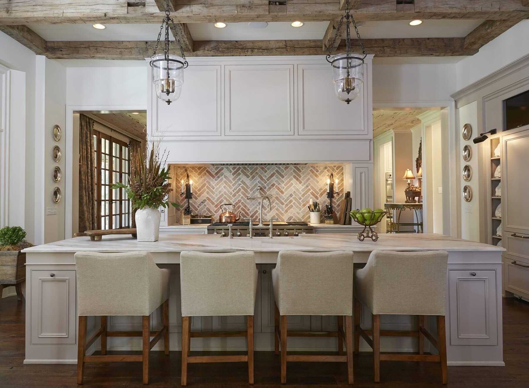 A touch of Old World, rustic charm in the reclaimed wooden beams and brick backsplash interplay with elements of sheer elegance in this gorgeous kitchen.