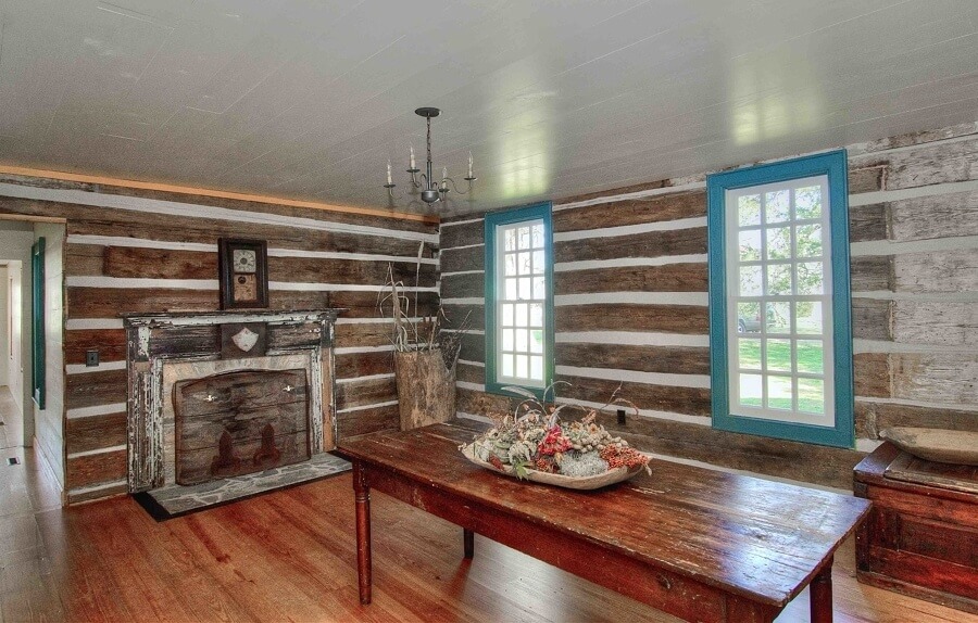 A dining room includes the cozy factor of log walls.