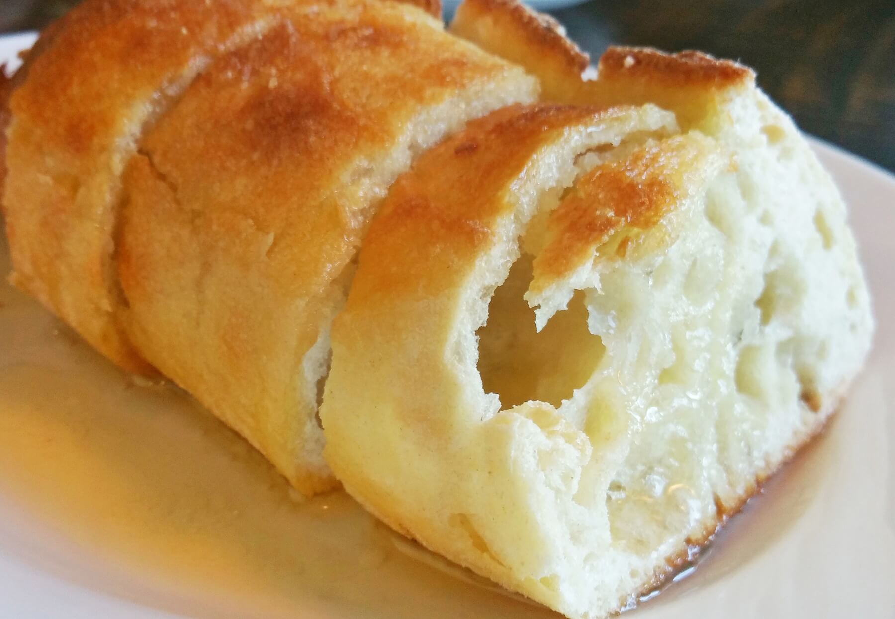 Warm crusty baguette is served with melted butter for a decadent start to the meal.