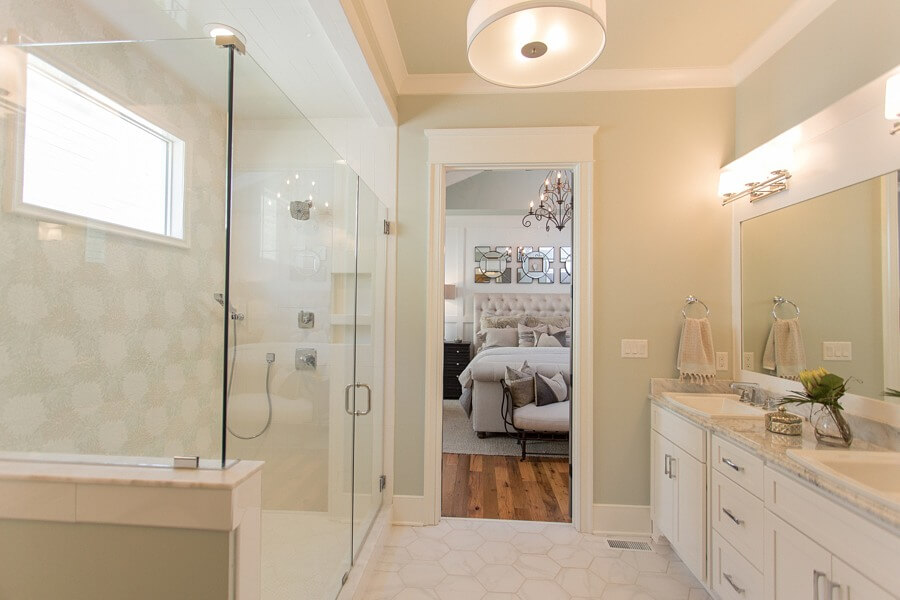 The master bath evokes luxe simplicity, including custom glass tile feature wall worthy of the glass shower. White cabinetry and simple fixtures keep the space serene and airy. 