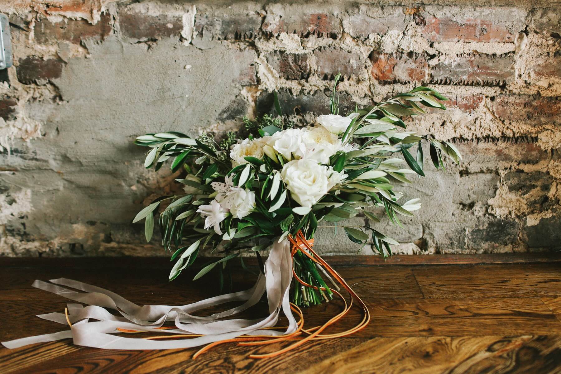 We are drooling over this bouquet — effortlessly gathered greenery with white lisianthus and alstroemeria tied with strands of gray ribbon and brown leather? To-die-for!