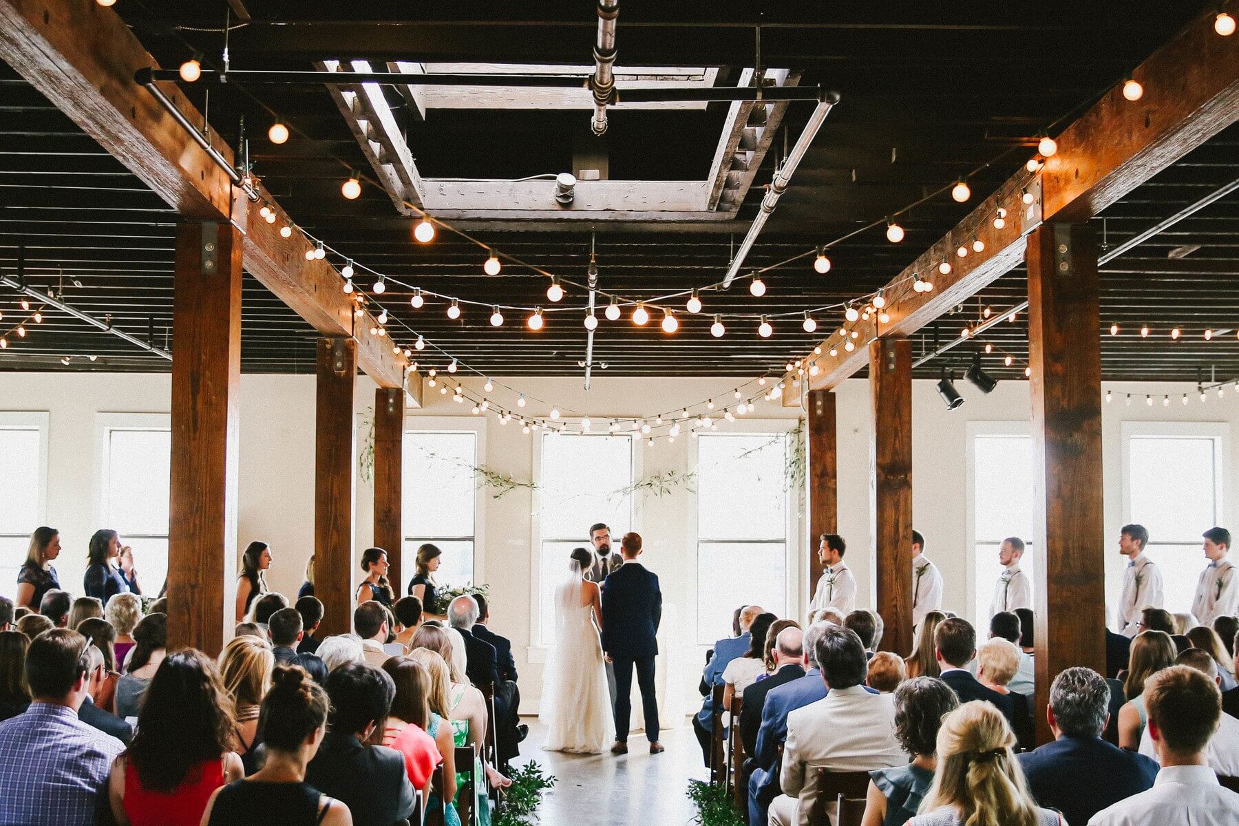 This warm industrial space, flooded in natural light and twinkle lights, was the perfect wedding venue for this cool couple.