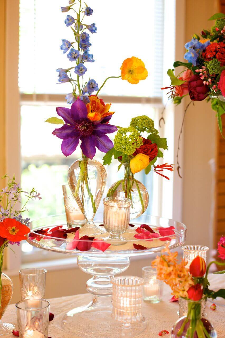 Bright pops of color stand out amongst glass and candles creating a romantic, summer table. Image: Beth Hontzas