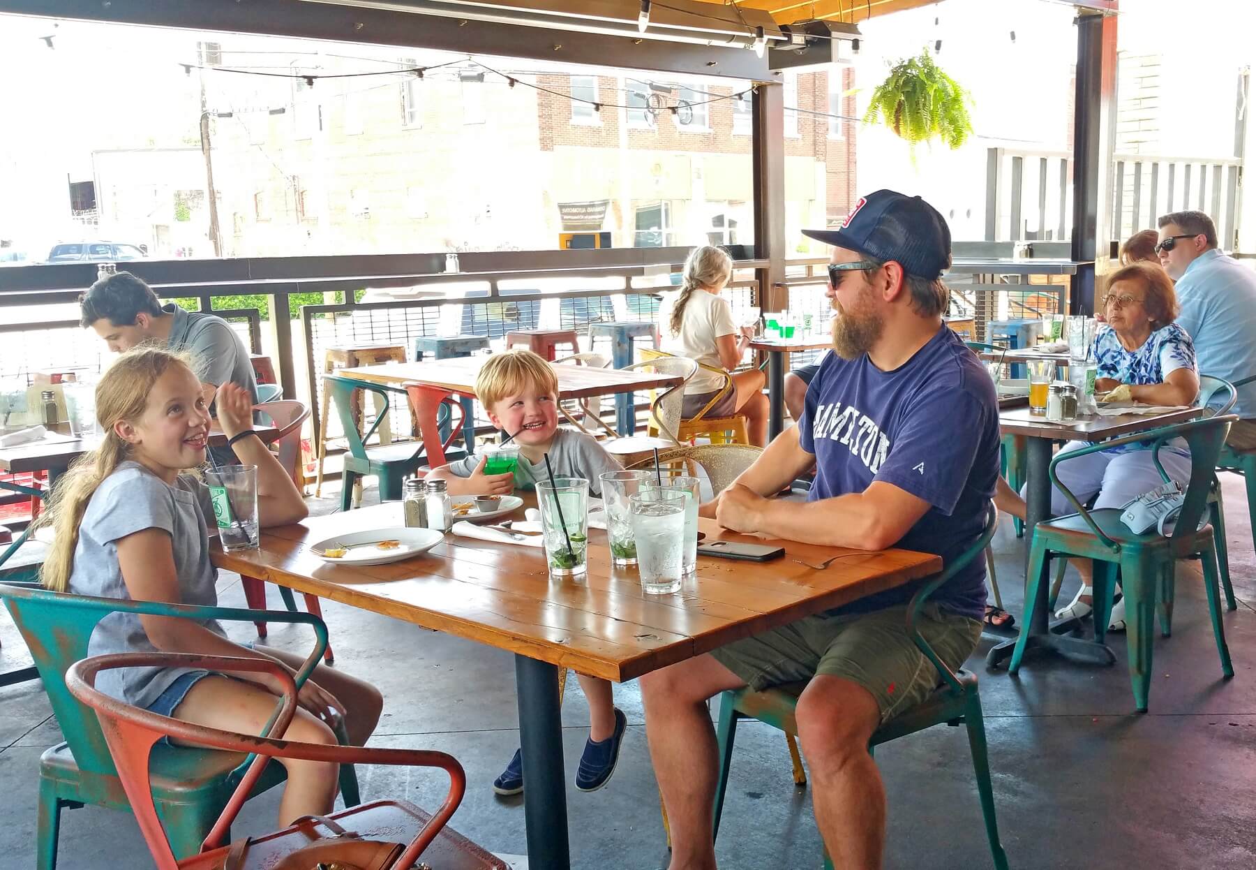 What to Do in Avondale, the "Ham's" Hippest Haven A family goofs off on the breezy covered patio overlooking the hopping Avondale sidewalks, a perfect spot for people-watching!