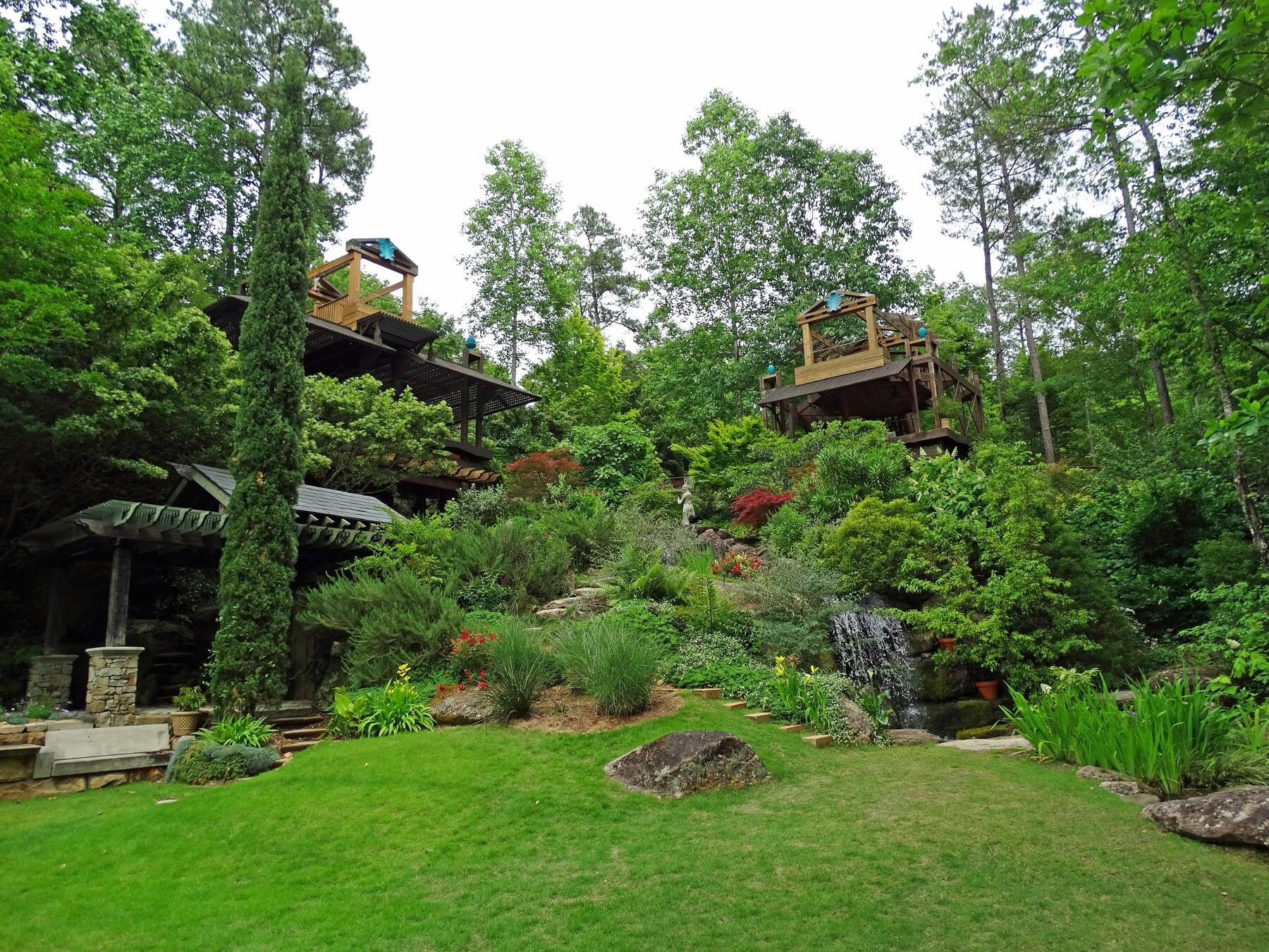 From the waterside green space, a winding stone stairway leads up towards a beautiful swimming hole.