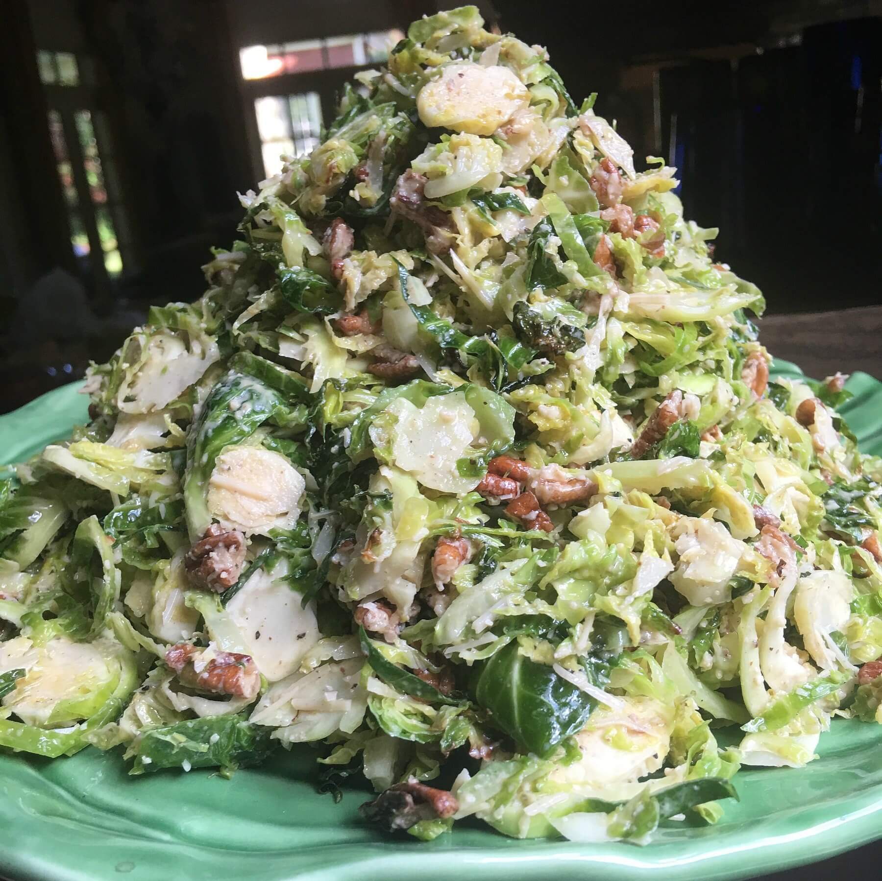 12 Easy Salad Recipes for Summer - 5 shaved Brussels Caesar salad with pecans piled high on a plate