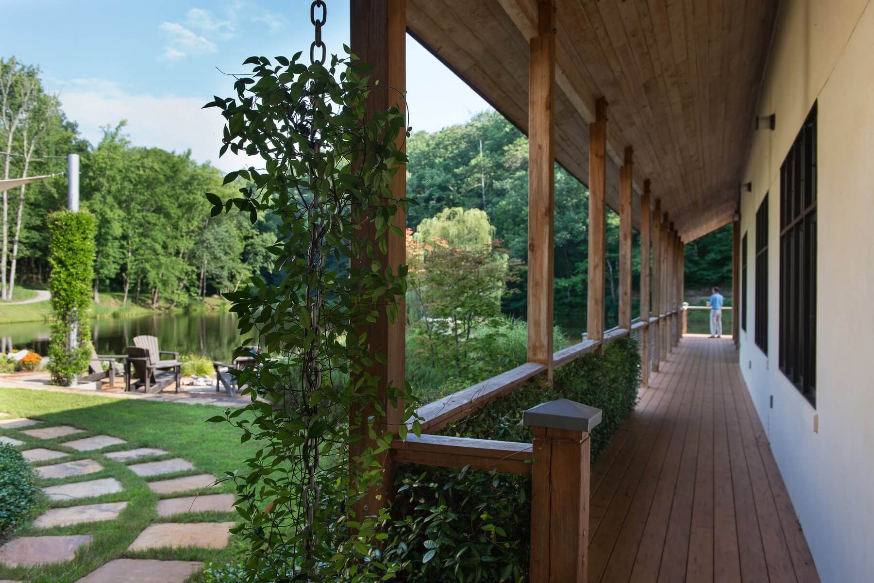 The wraparound porch is adjacent to a nearby lakeside seating area. The wraparound porch is adjacent to a nearby lakeside seating area.