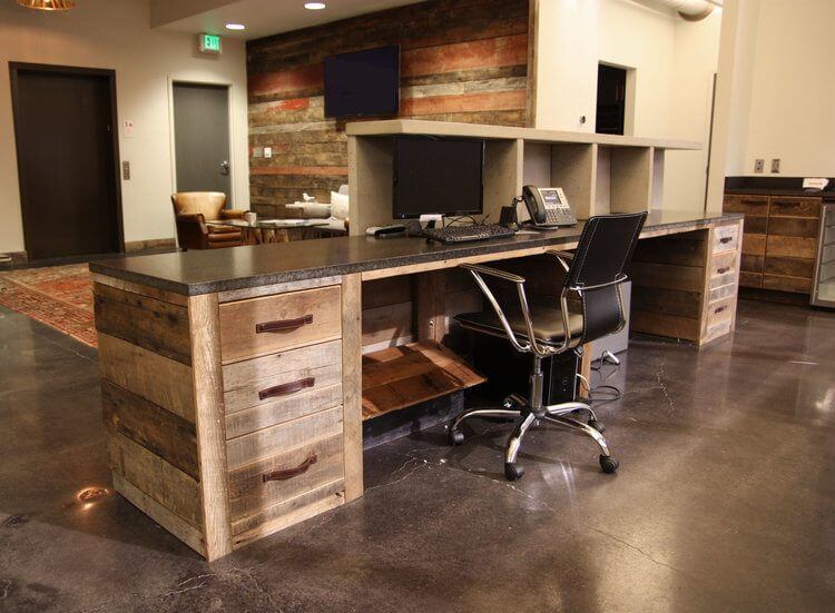 The reclaimed wood theme is woven throughout the space. Here, the receptionist's reclaimed wood desk features some handsome leather handle pulls. The reclaimed wood theme is woven throughout the space. Here, the receptionist's reclaimed wood desk features some handsome leather handle pulls.