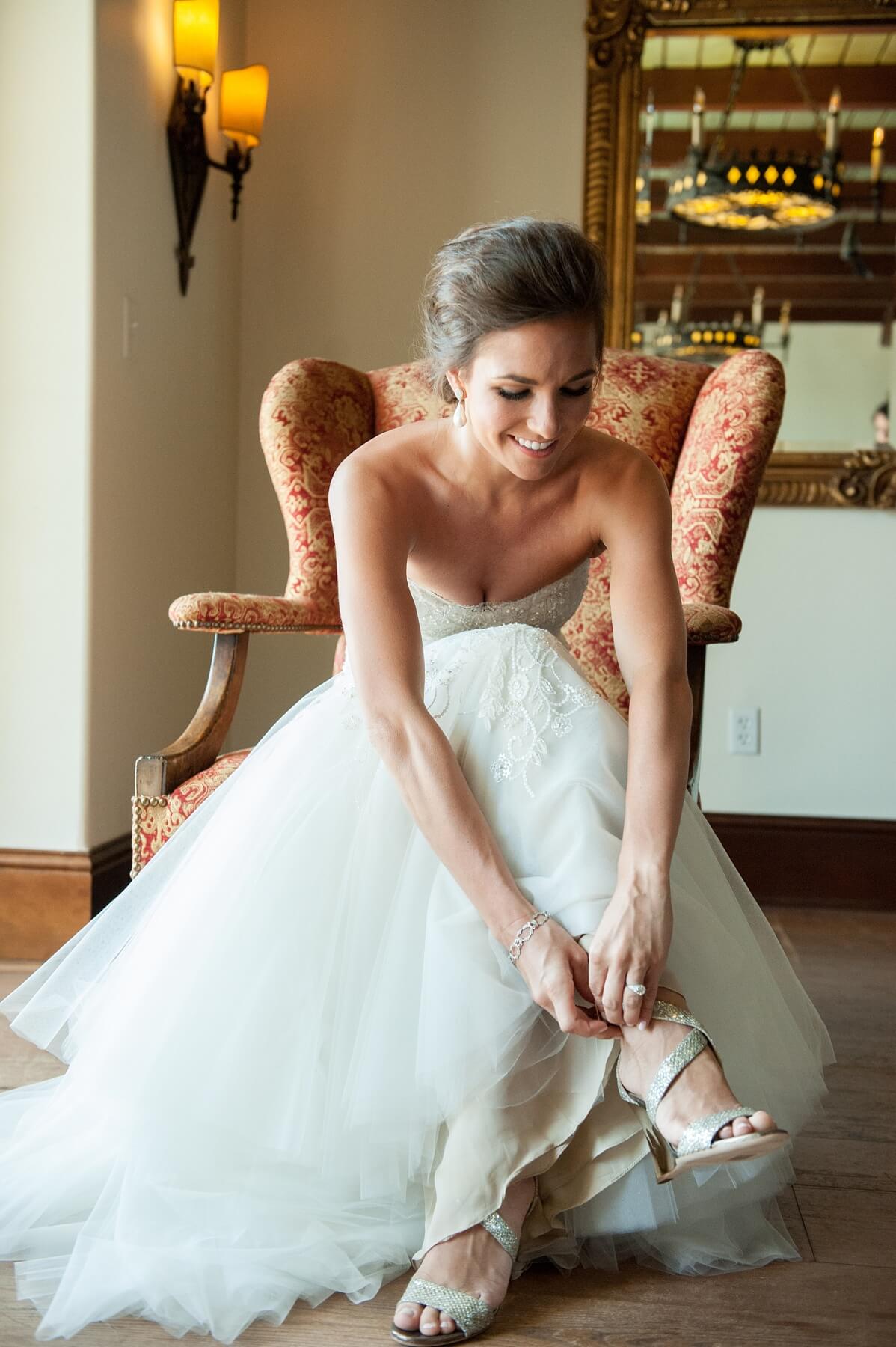 Holly kept with tradition and incorporated something old, new, borrowed and blue into her wedding-day attire. Beautiful pearl and diamond earrings from Jordan Alexander were a wedding gift from her parents and her “something new”; she borrowed her sister’s old diamond bracelet, which she wore on her own wedding day; and she added a touch of blue with her garter. And, of course, a sixpence for her shoe!