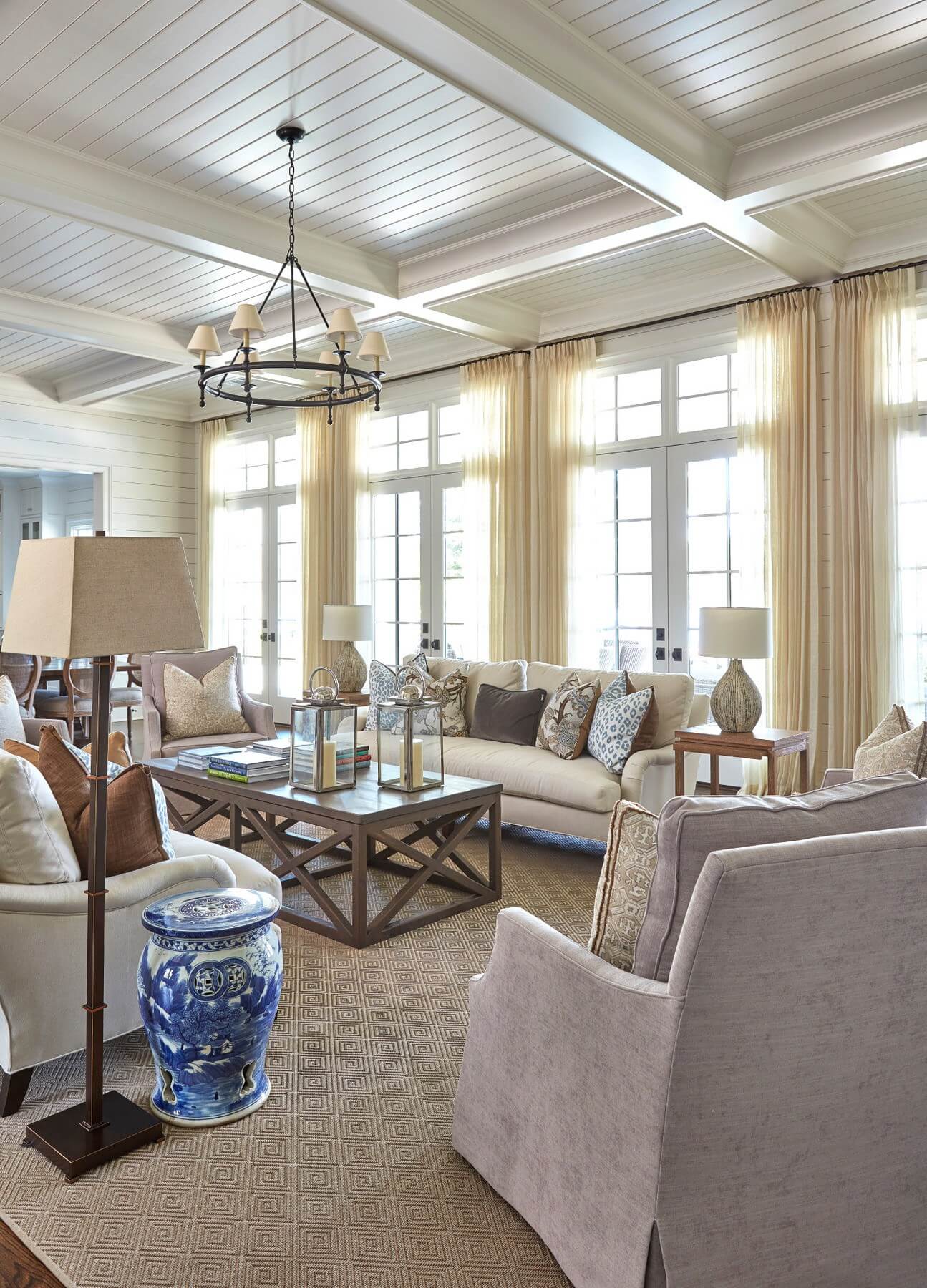 The living room includes two custom sofas from LeeIndustries.com, paired with four swivel chairs that can face the kitchen or television for versatility. A large coffee table, sturdy enough for feet to be propped on, anchors the room. “The homeowner and I share a love for blue-and-white porcelain, so we added the heavy garden stools for an additional place to sit a phone or glass,” says Maggie. The living room includes two custom sofas from LeeIndustries.com, paired with four swivel chairs that can face the kitchen or television for versatility. A large coffee table, sturdy enough for feet to be propped on, anchors the room. “The homeowner and I share a love for blue-and-white porcelain, so we added the heavy garden stools for an additional place to sit a phone or glass,” says Maggie.