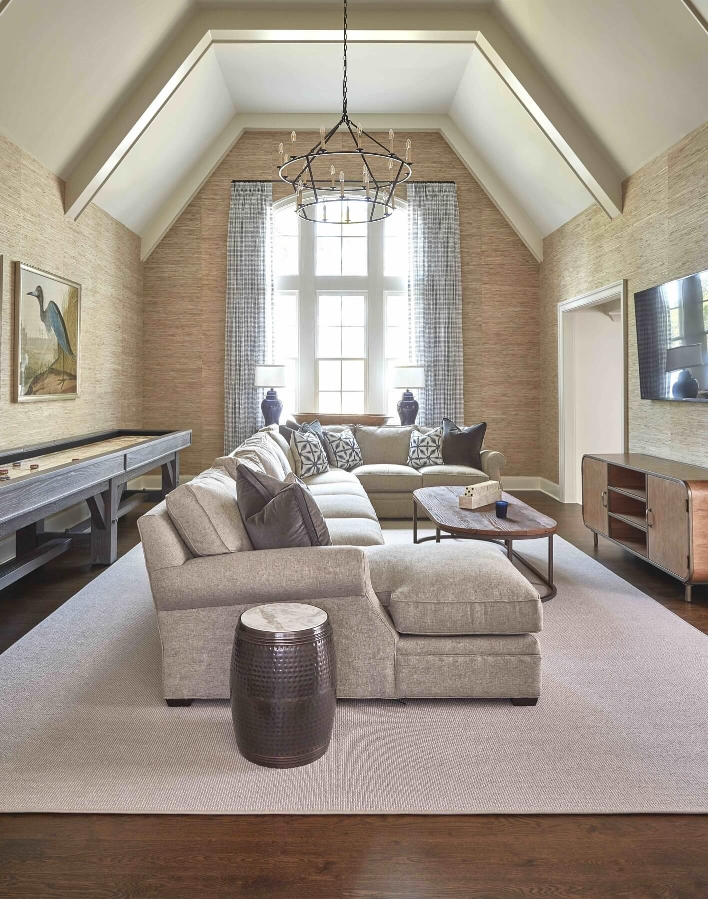 “On the chance that a heavy rain rolls in, this game room space gives everyone a fantastic alternative to stay inside,” says Maggie. “We outfitted it with a custom shuffle board table, a giant sectional, pool table, and gaming station, with grass-cloth on the walls for both the texture and the sound absorption.”