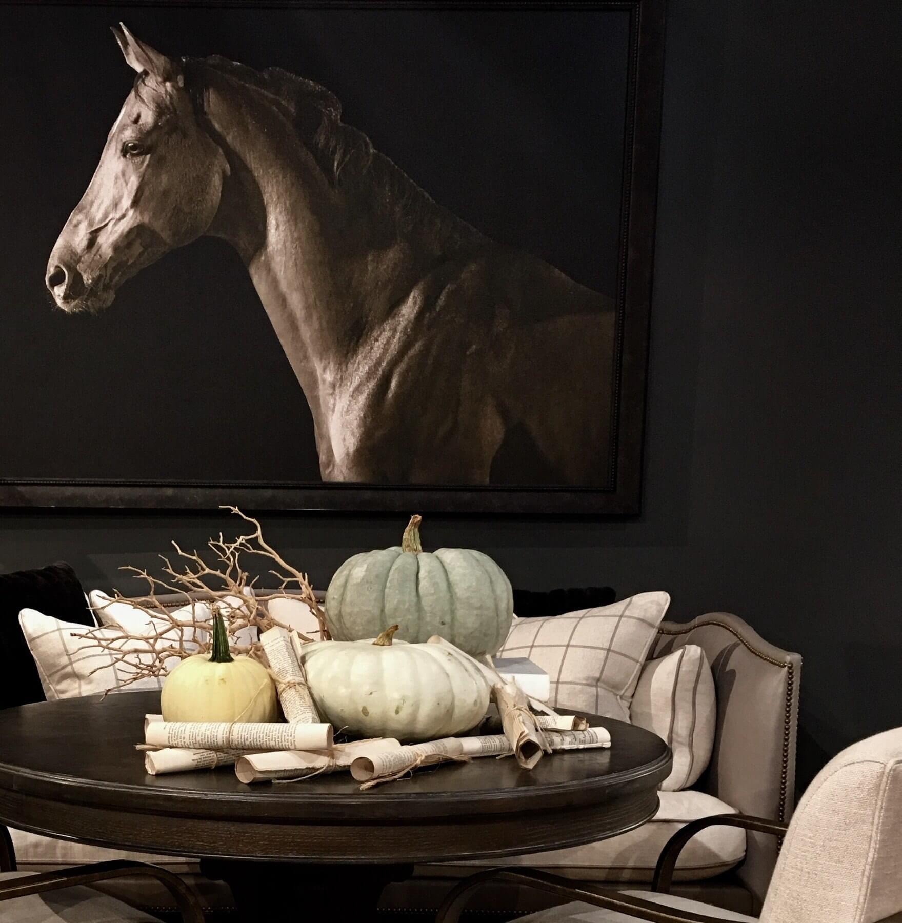 This autumnal tablescape foregoes the classic orange-and-black of Halloween for a softer look. Embracing the cool grays of the room, these pumpkins in muted tones are perfectly complemented by sepia-toned newspaper and branches. Image: Shelley Dowell of Carriage House Interiors & Home Furnishings This autumnal tablescape foregoes the classic orange-and-black of Halloween for a softer look. Embracing the cool grays of the room, these pumpkins in muted tones are perfectly complemented by sepia-toned newspaper and branches. Image: Shelley Dowell of Carriage House Interiors & Home Furnishings