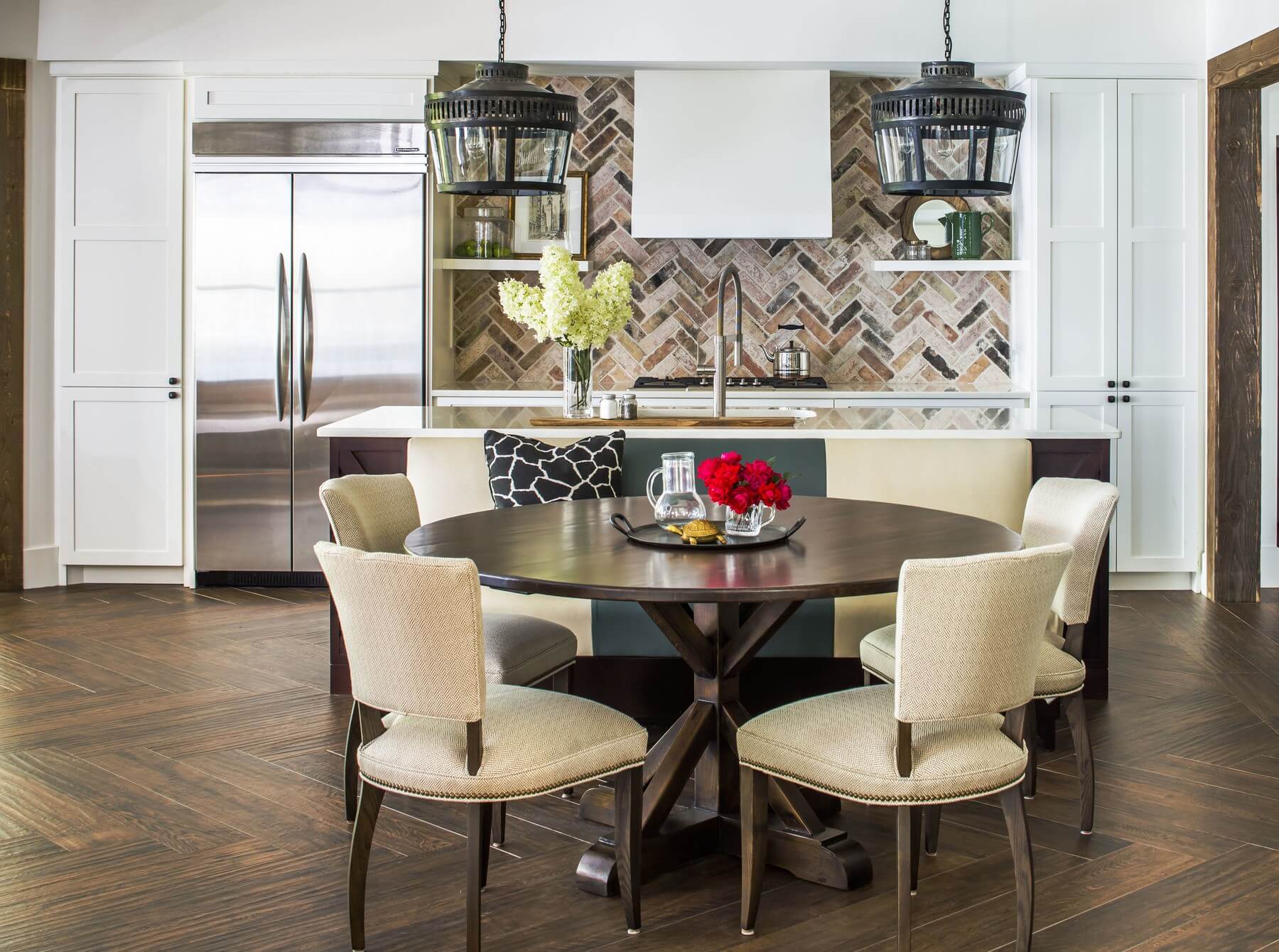 To make each room special, flooring in each room is a bit different. The herringbone pattern in the wood floor is mimicked in the brick backsplash. A built-in banquette adds comfortable kitchen seating.