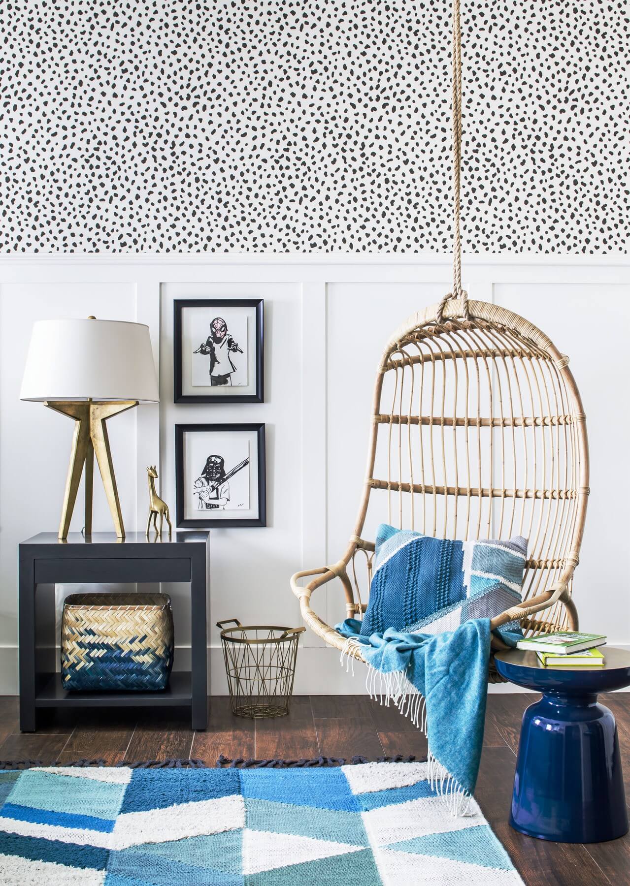 A hanging chair and wallpapered walls contribute to the whimsical boy’s room.