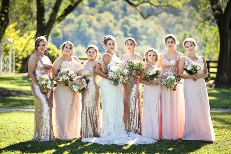 Megan's bridesmaids, dressed in blush tones and gilded sparkles, were a stunning complement to her show-stopping white gown. Richwood on the River