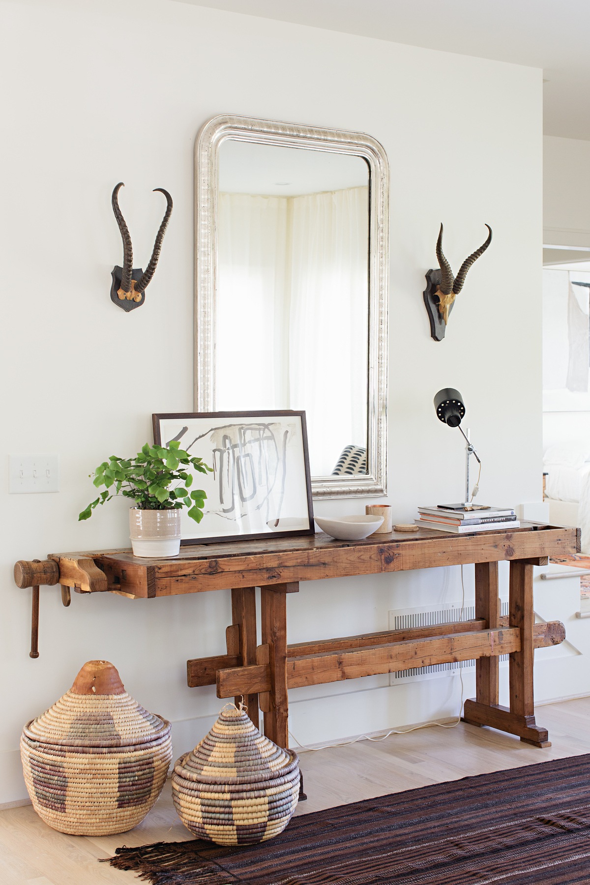“We knew we wanted something primitive here to mix with the clean lines of the architecture,” says Fran. “The Thrower’s found the perfect source during their travels to Colorado and sourced this table from a Swedish antique dealer. It is an antique workbench. The juxtaposition of the traditional Louis Philippe mirror over this piece is what really makes this vignette sing.” Scandinavian-style family home