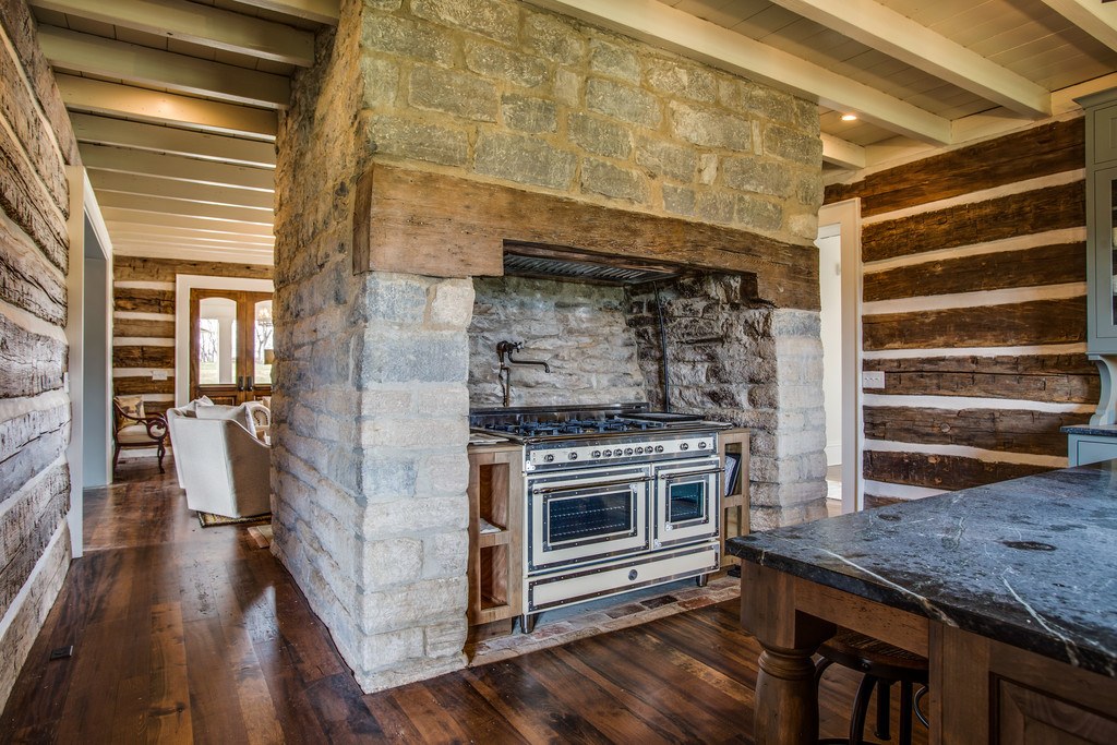 A gas stove is neatly tucked into a massive limestone structure that's original to the home.