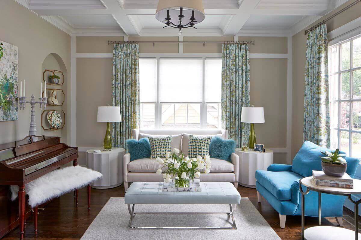 The living room serves as a place for the family to gather and play piano or read, but it also needed to be a strong “first impression” room, says the designers. To fulfill the homeowner’s request for happy colors, Kandrac & Kole chose a lively patterned fabric by https://www.thibautdesign.com for window treatments, and original art from pryorfineart.com.