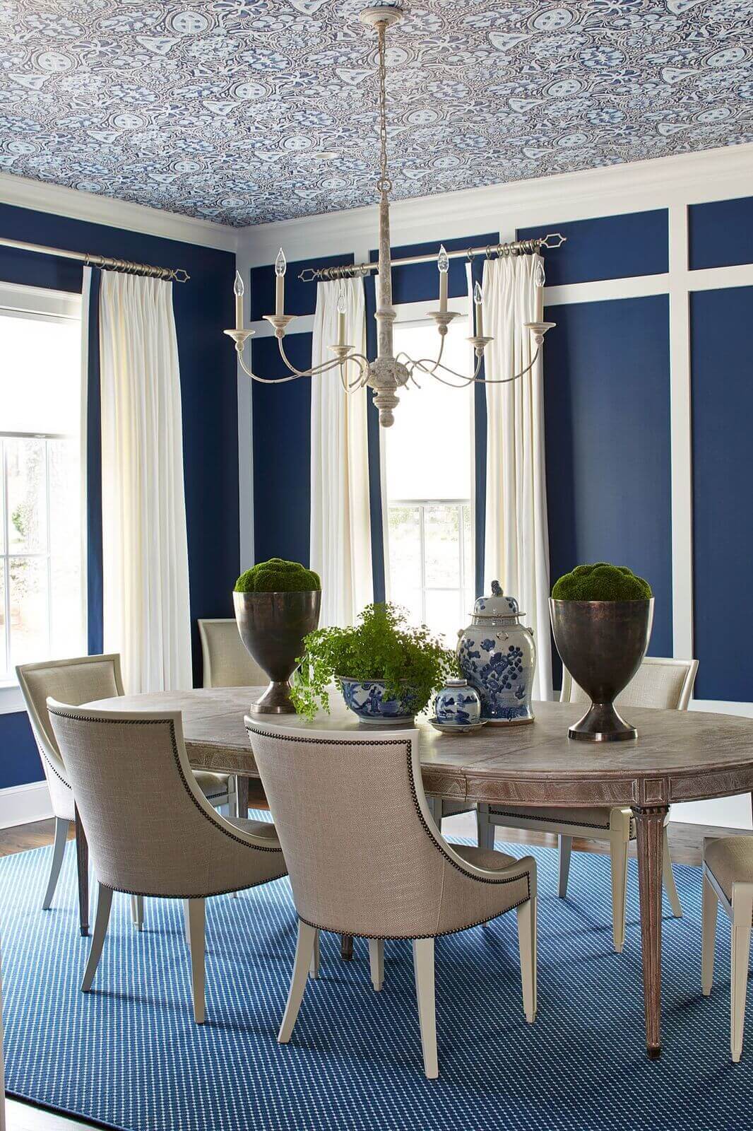 A wallpapered ceiling gives the dining room a strong focal point, further enhanced with a new light fixture and paint. “We went round and round about how to treat the millwork on the main wall and finally decided that we liked the architectural interest it provided if we painted it the trim color,” says Kelly.
