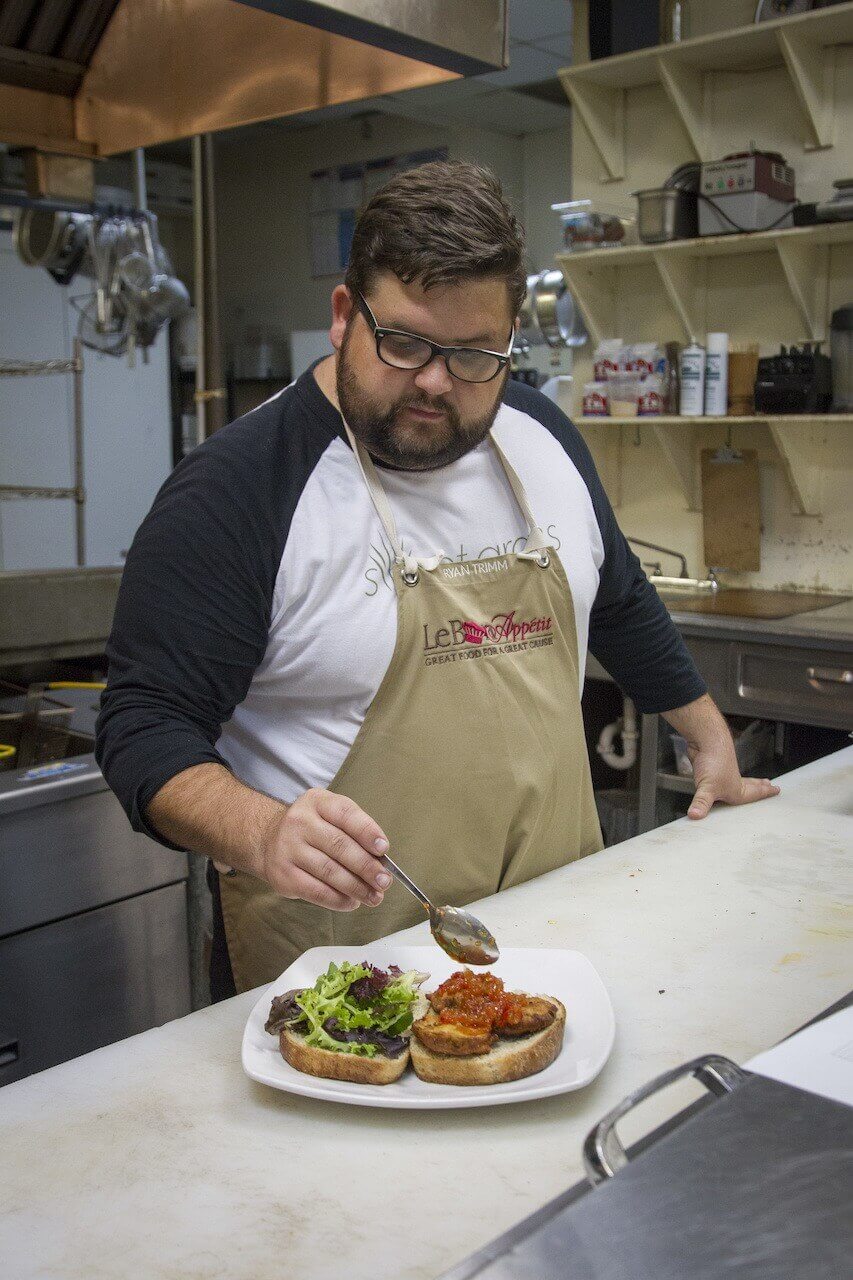 Ryan adds the house made sweet pepper relish to the sandwich. All that's missing is the bacon!