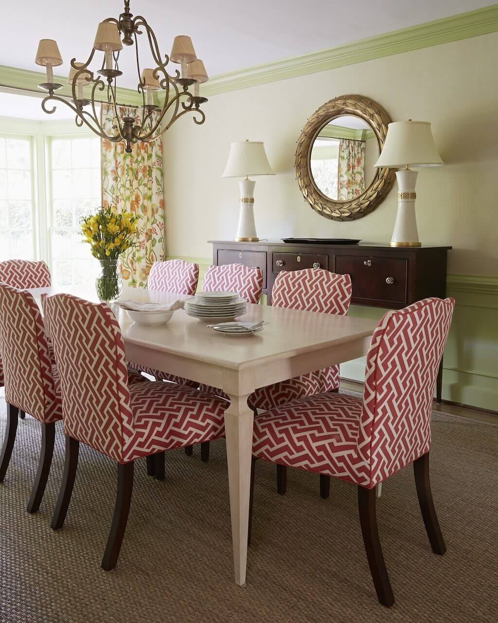 A sideboard by Kittinger and lamps from Mrs. Howard complement the red Quadrille fabric on dining room chairs.