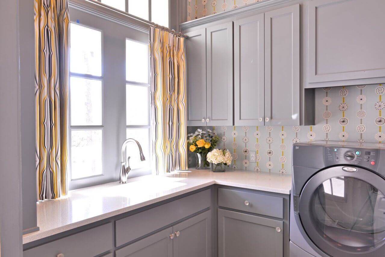 Even the laundry room stands out, thanks to drapery fabric from Duralee. Benjamin Moore’s Shaker Gray covers the cabinetry.