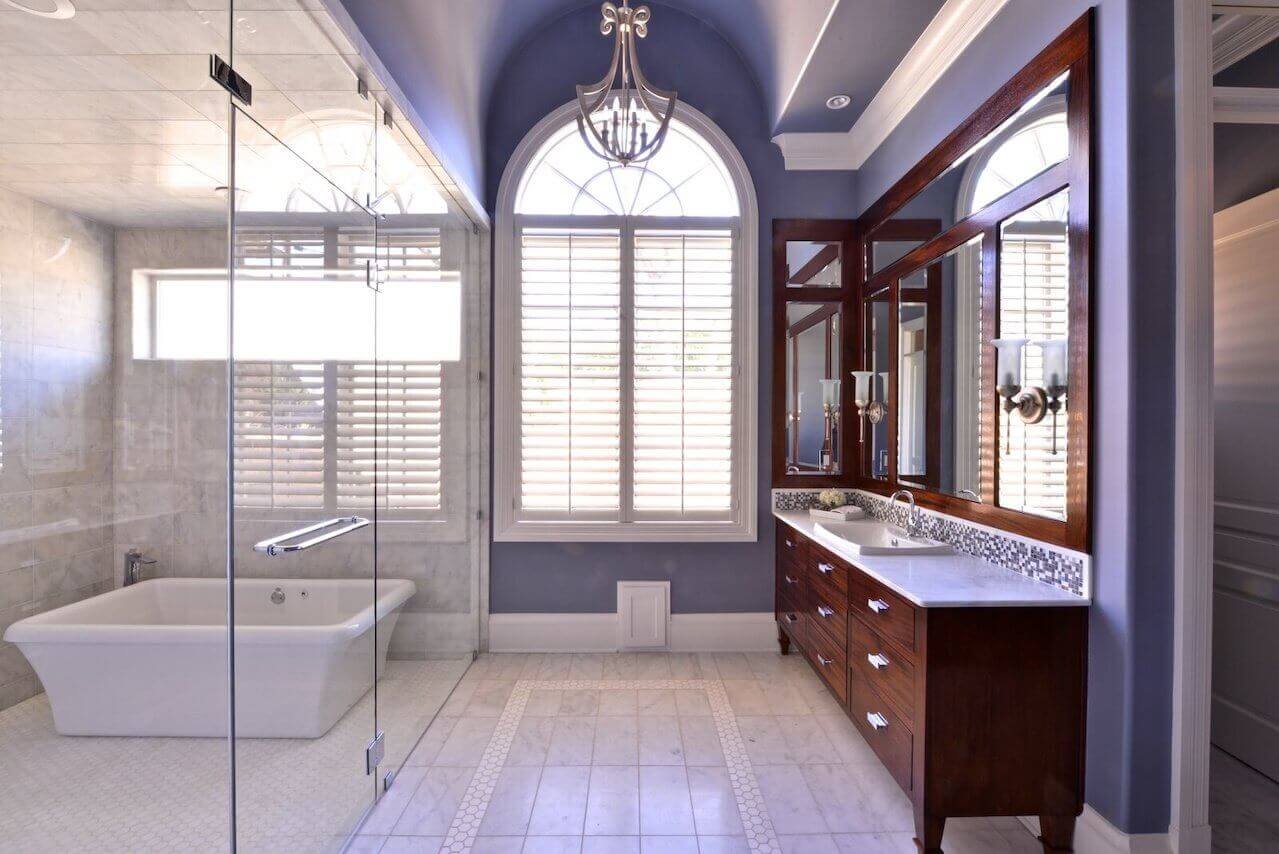 Custom vanities have a furniture-like look in the master bath. The designer combined the shower and tub into one spa-like “wet room.”