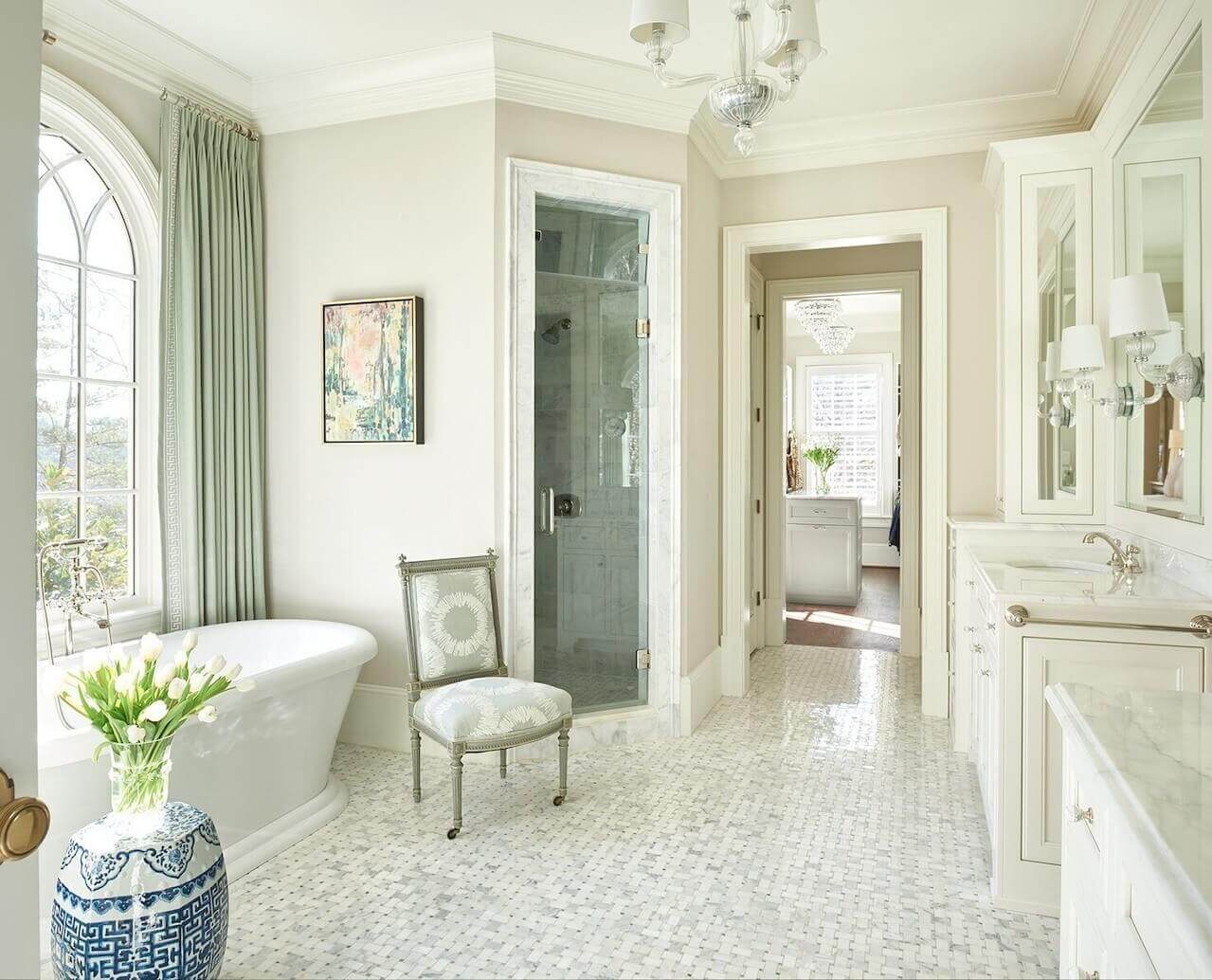 Luxurious window treatments—made from Duralee fabrics—soften the free-standing tub. Soft shades of green elevate the bathroom from a typical all-white scenario.