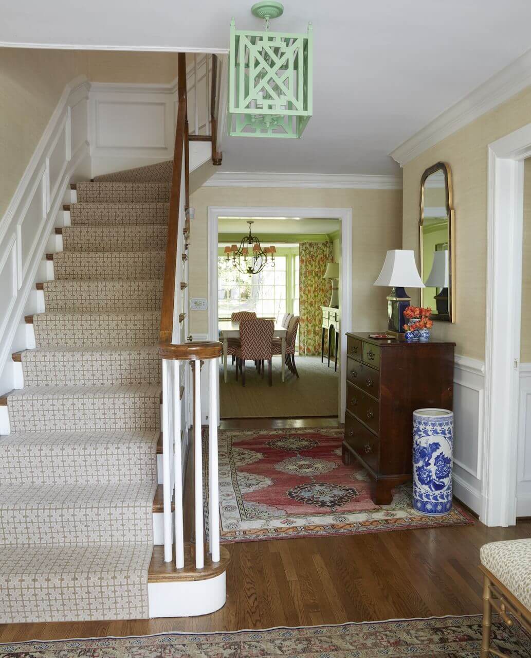 A striking light fixture from John Roselli Antiques in New York adds just the right amount of unexpected alongside classic foyer furnishings.